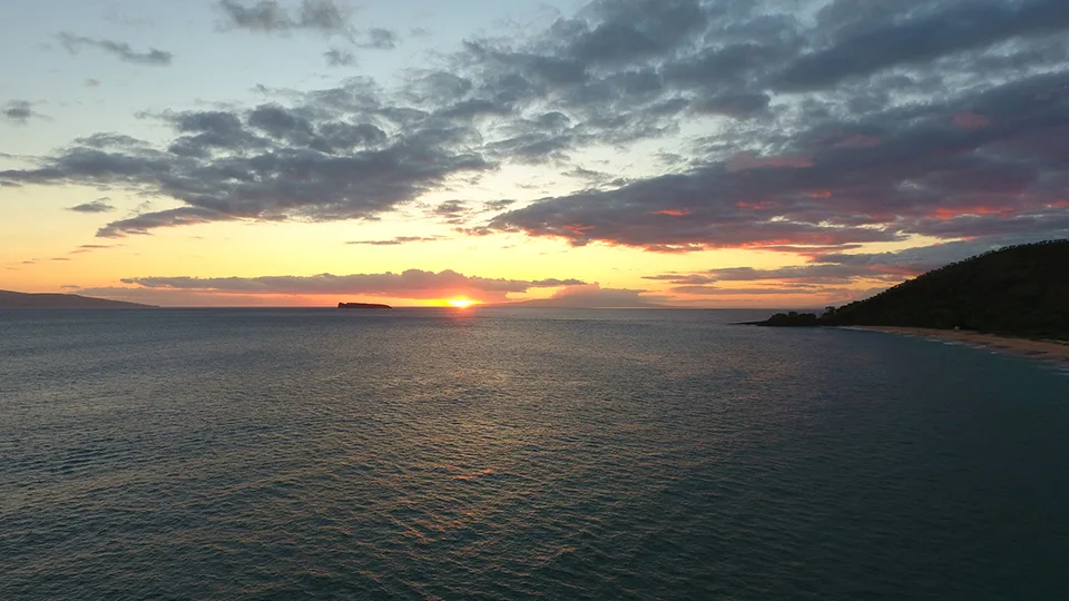 Sunset view from Big Beach in Maui, with the sun casting golden reflections across the calm ocean.