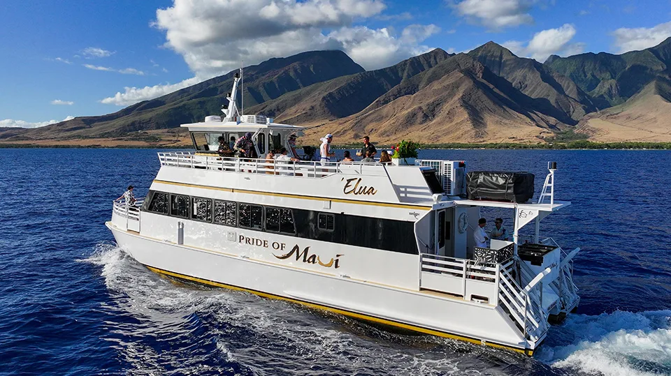 Pride of Maui ʻElua cruising near Maui shore with mountainous backdrop