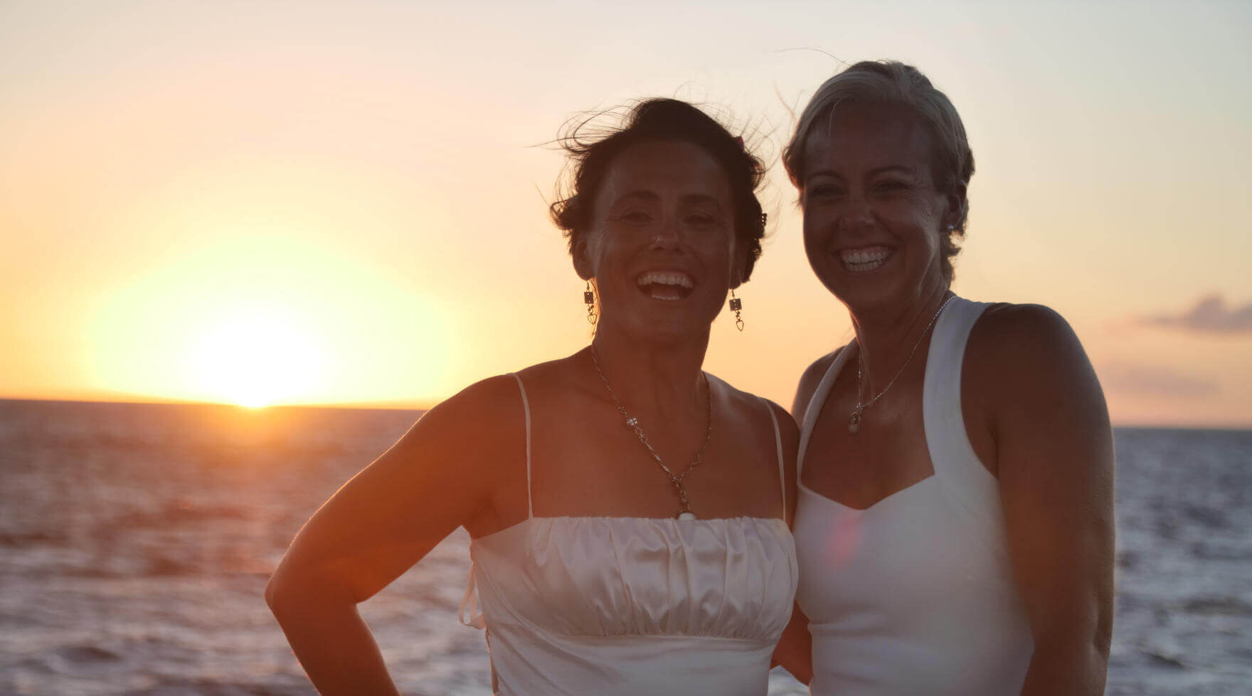 Couple Smiling with Sunset in Background on a Pride of Maui Wedding Cruise