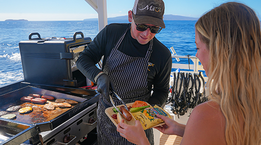 Captain grilling lunch on board the ‘Elua catamaran