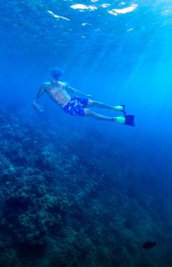 Snorkeler in clear blue water at Molokini